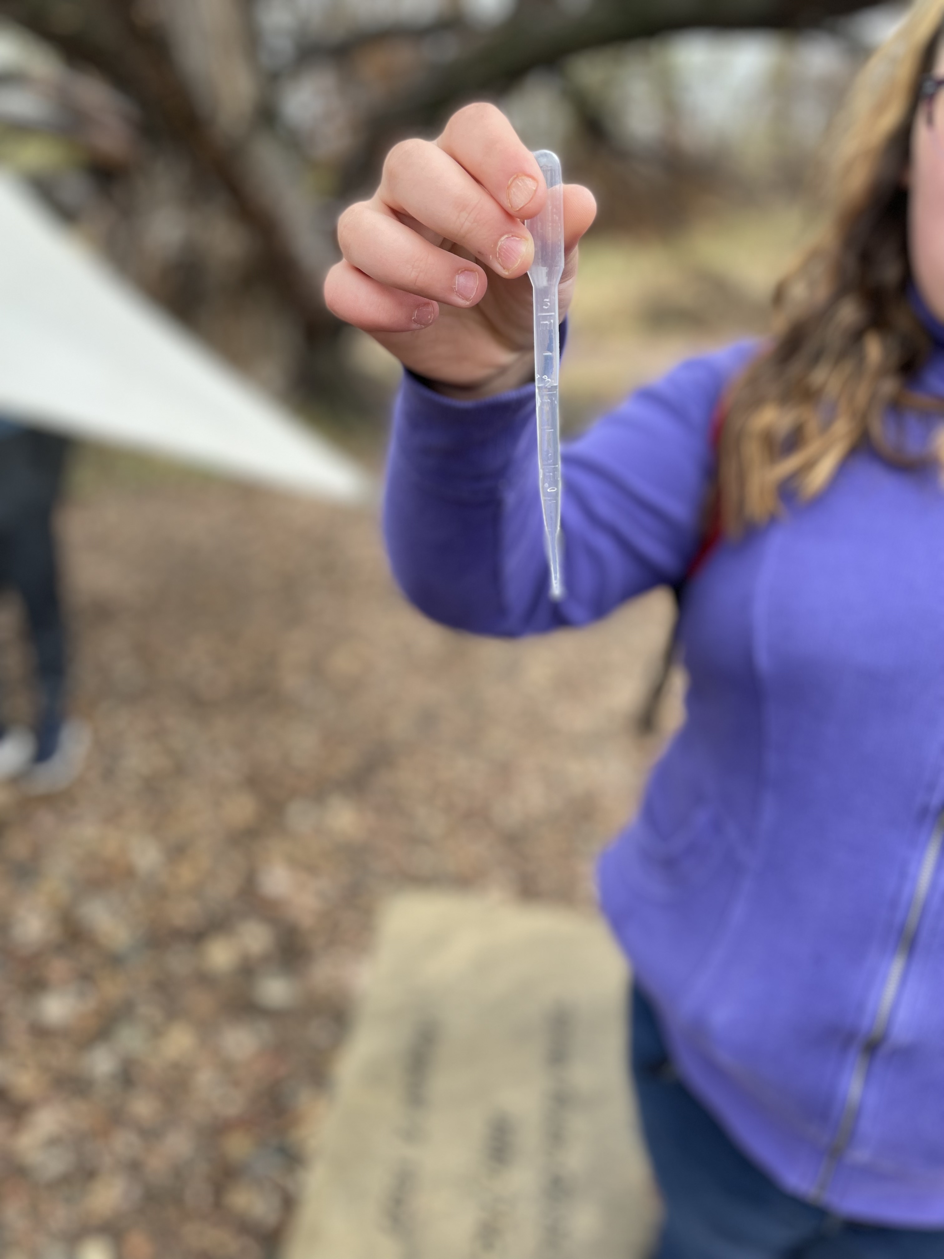 Irish Elementary student collecting river water sample in pipette